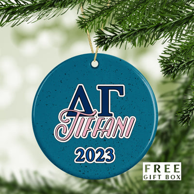 May include: A blue and white ceramic Christmas ornament with the letters &#39;AΓ&#39; in blue and the word &#39;TIFFANI&#39; in pink. The year &#39;2023&#39; is written in blue below the name. The ornament has a speckled blue background.