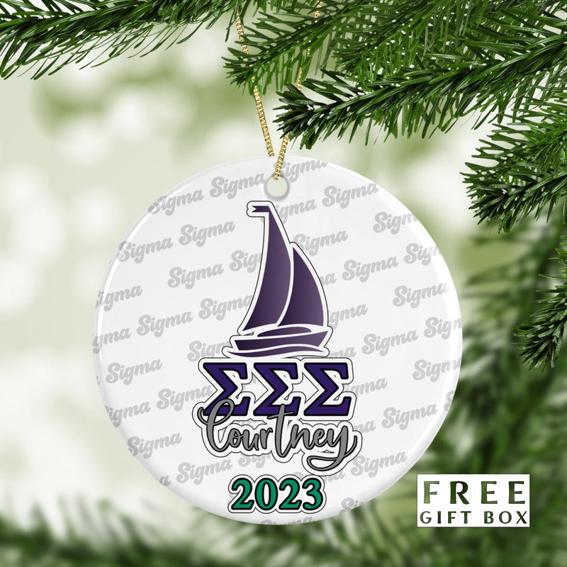May include: A white round ceramic ornament with a purple sailboat, the letters &